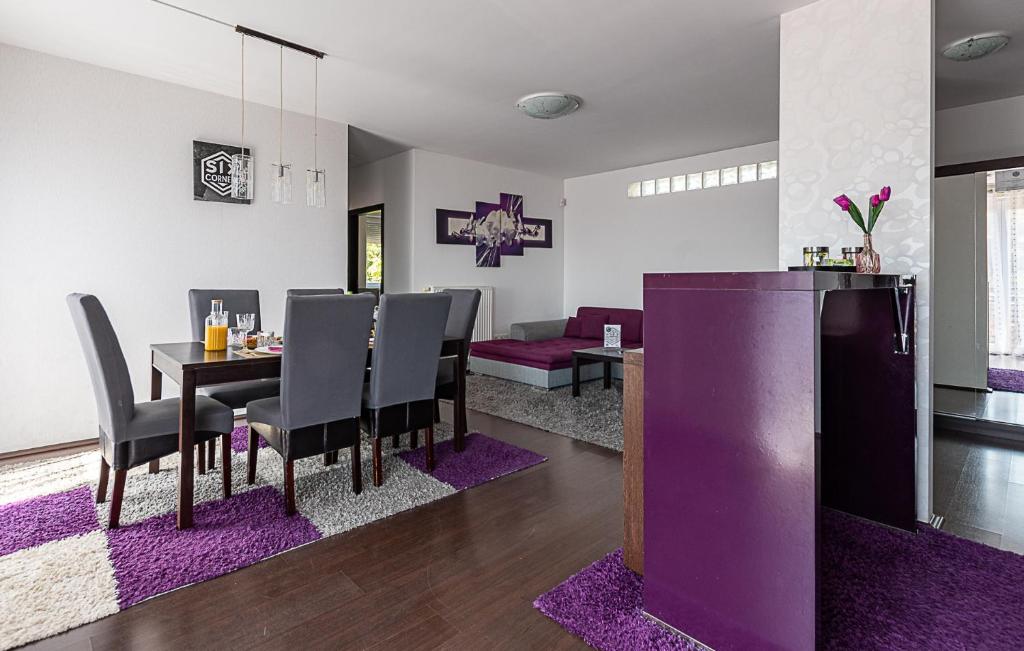 a dining room with purple chairs and a table at Six Corners Mystic Corner City View Balcony Apartment in Pécs