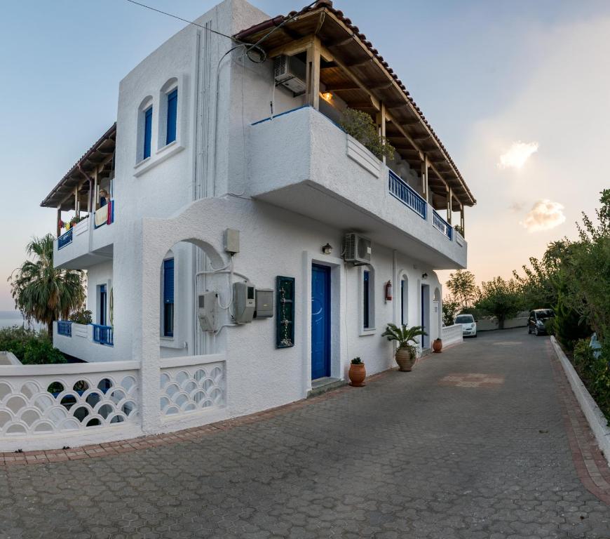 een wit gebouw met een balkon in een straat bij Creta Sky in Achlia