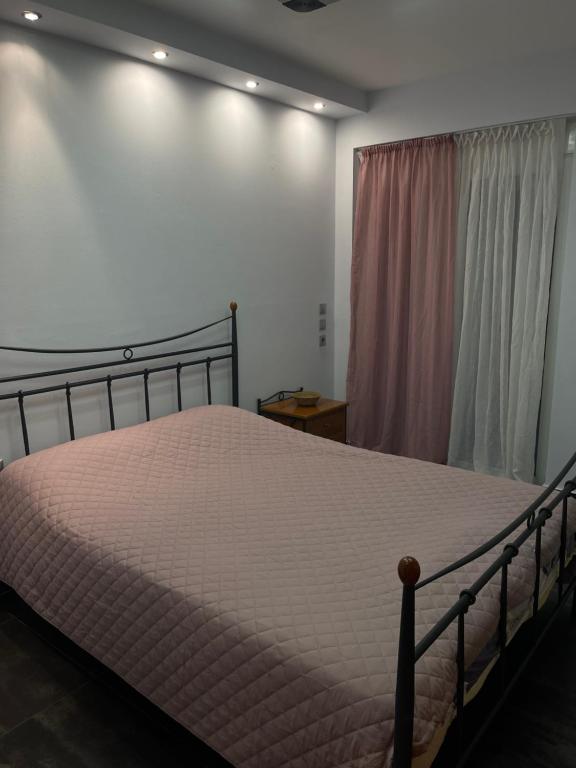 a bedroom with a bed and a window at Cozy beach apartment in Saronida in Saronida