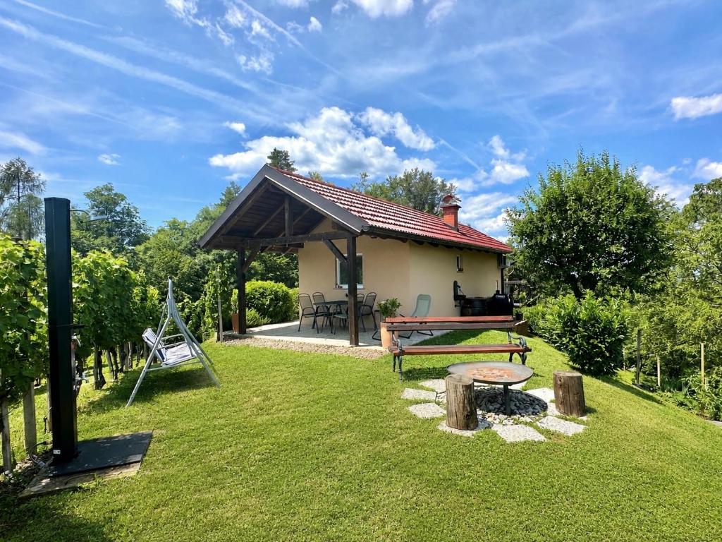 a house with a picnic table in a yard at Tomajna Vineyard Stay in Podlehnik