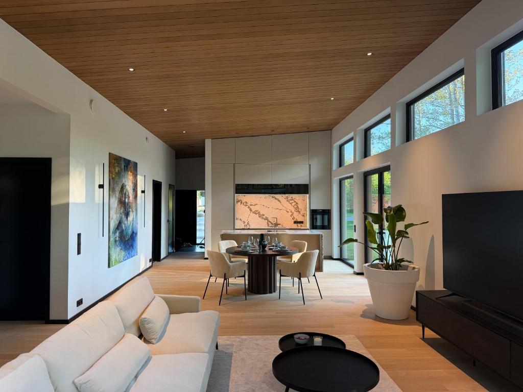 a living room with a couch and a table at Jõelähtme Golf Villa with Sauna and Terrace Grill - near EGCC Golf Course in Manniva