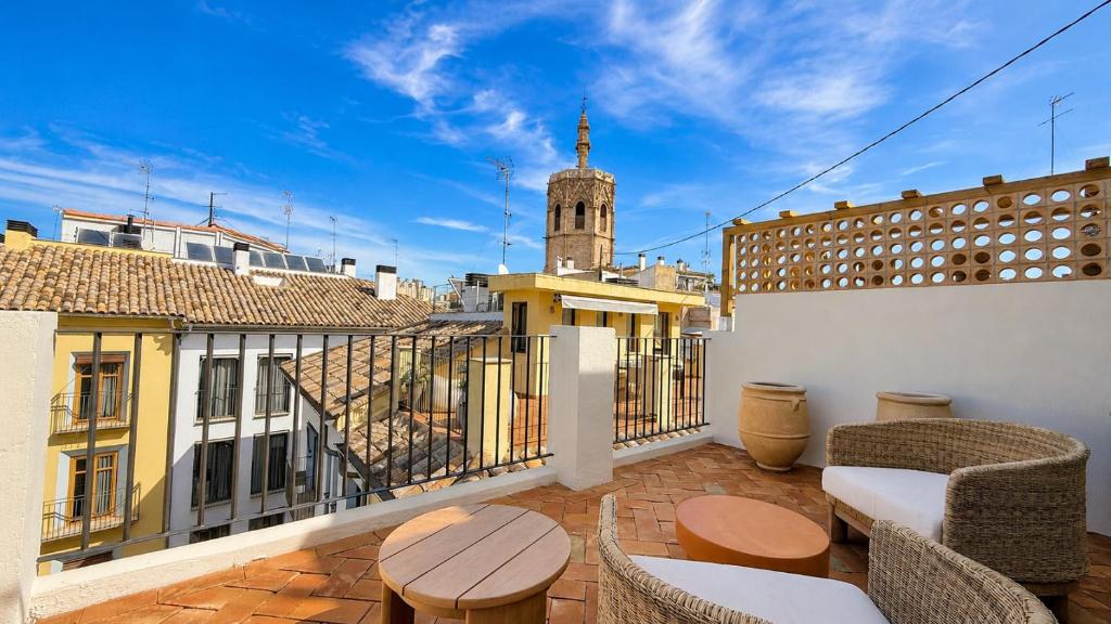 a balcony with chairs and tables on a building at Cosy Rooms Tapinería in Valencia