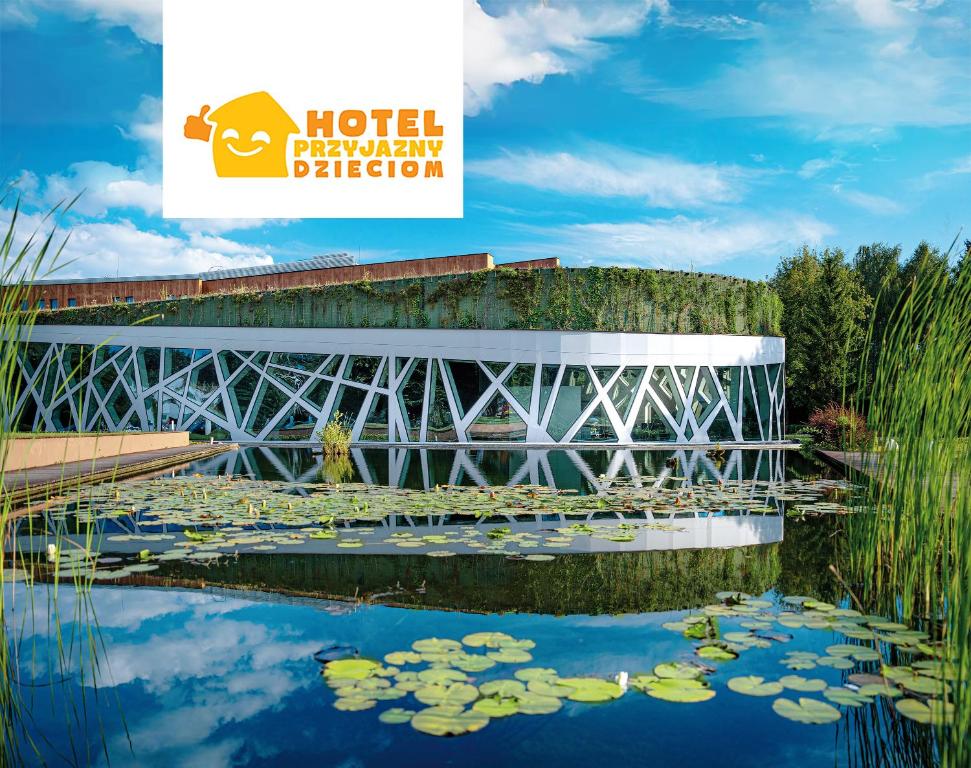 a bridge over a pond with water lilies at Hotel Narvil Conference & Spa in Serock