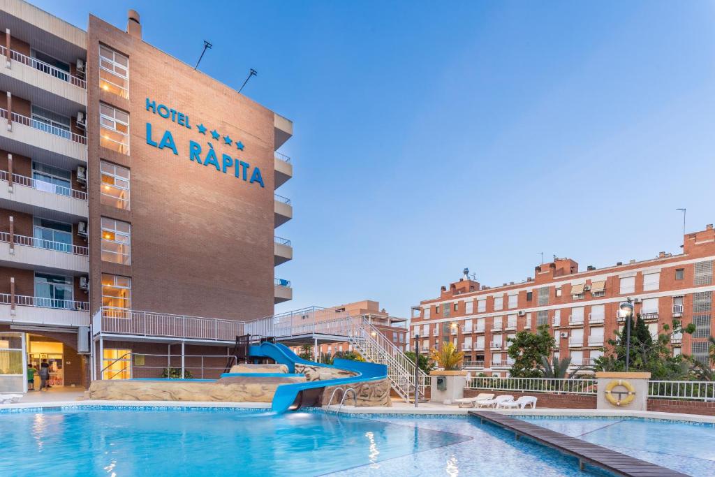 a swimming pool with a slide in front of a building at Hotel La Rápita in Sant Carles de la Ràpita