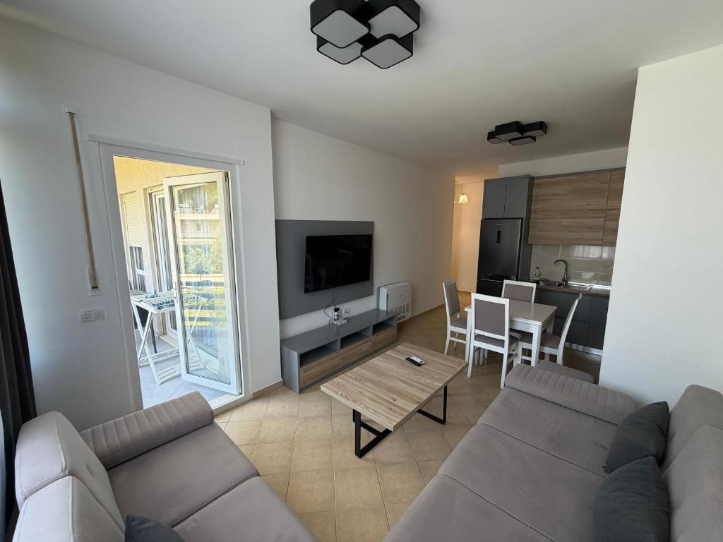 a living room with a couch and a table at Near movenpic apartament in Draç