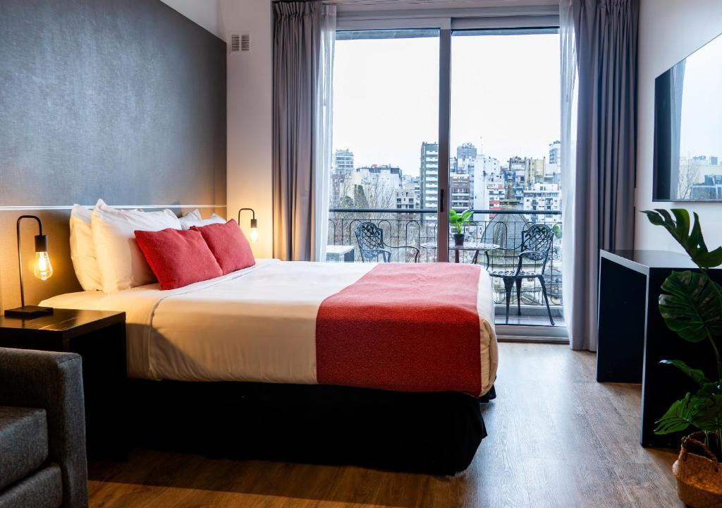 a hotel room with a bed and a large window at Reco by DOT Suites in Buenos Aires