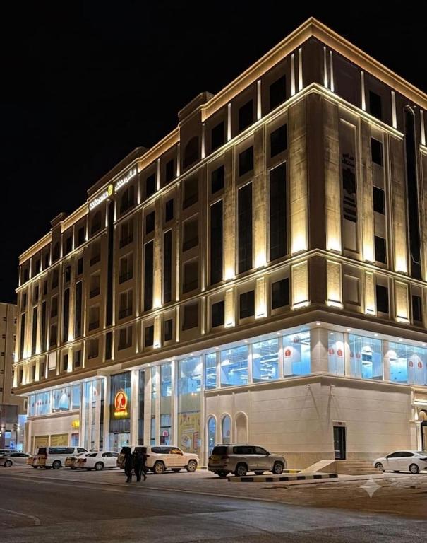 a lit up building with cars parked in front of it at SAS Central in Salalah