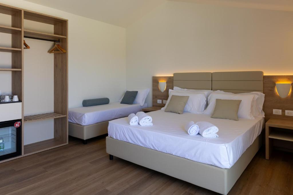 a bedroom with two beds with white towels on them at Modica Beach Resort in Marina di Modica
