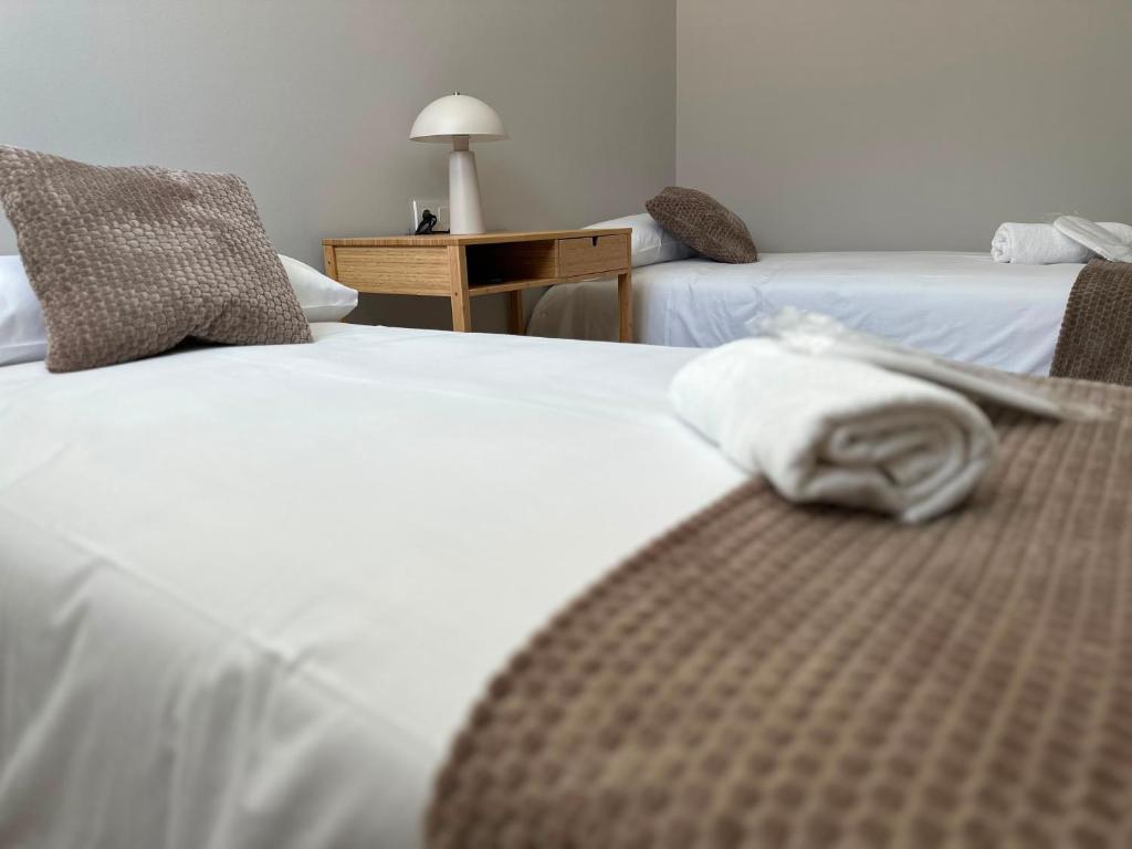 a hotel room with two beds with towels on them at Pensión Eirín VI in Caldas de Reis