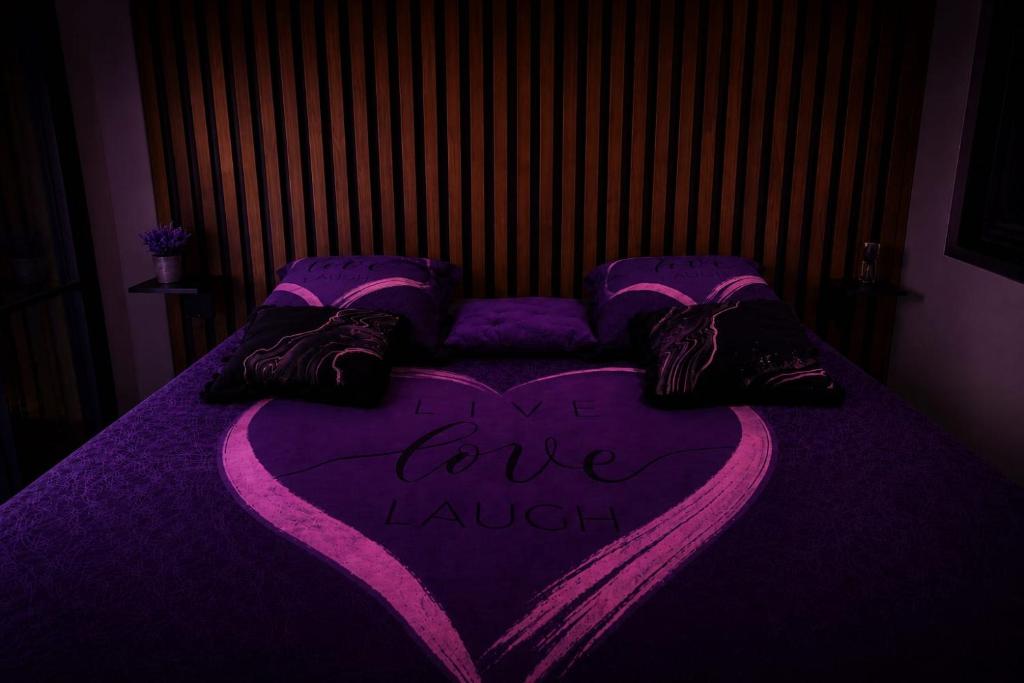 a purple bed with a heart with the words i loveiane at Lov'appart in Les Anses-dʼArlets