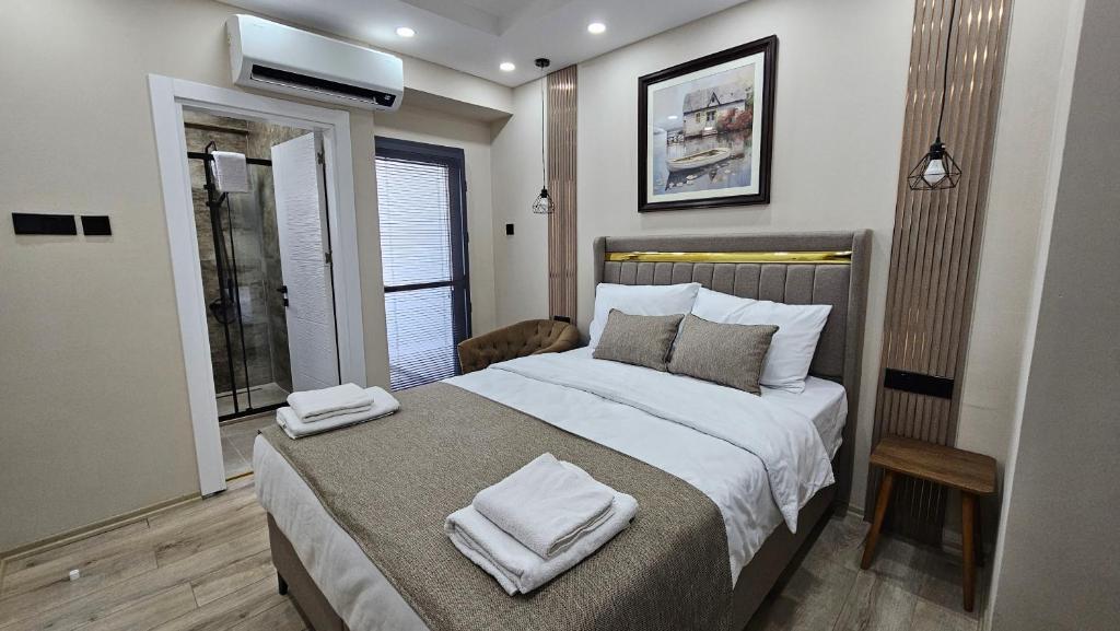 a bedroom with a large bed with towels on it at Dereboyu Premium in Nicosia