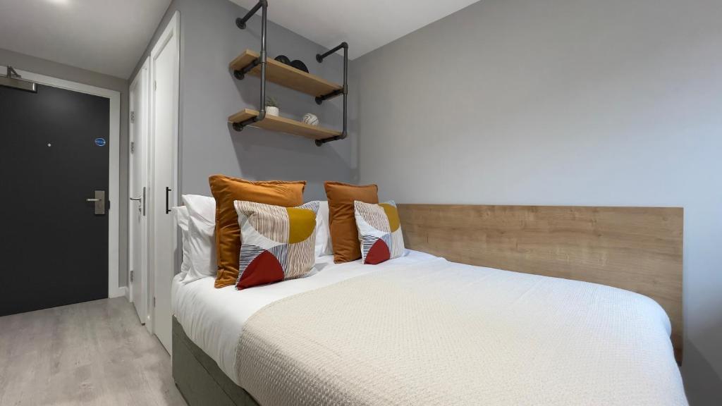 a bedroom with a bed with orange and white pillows at The Coal Yard in York