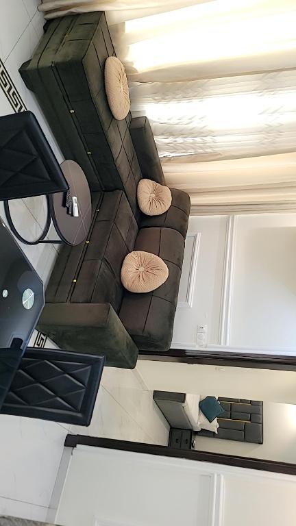 a living room with a brown couch with pillows at Cité La Vie in Douala