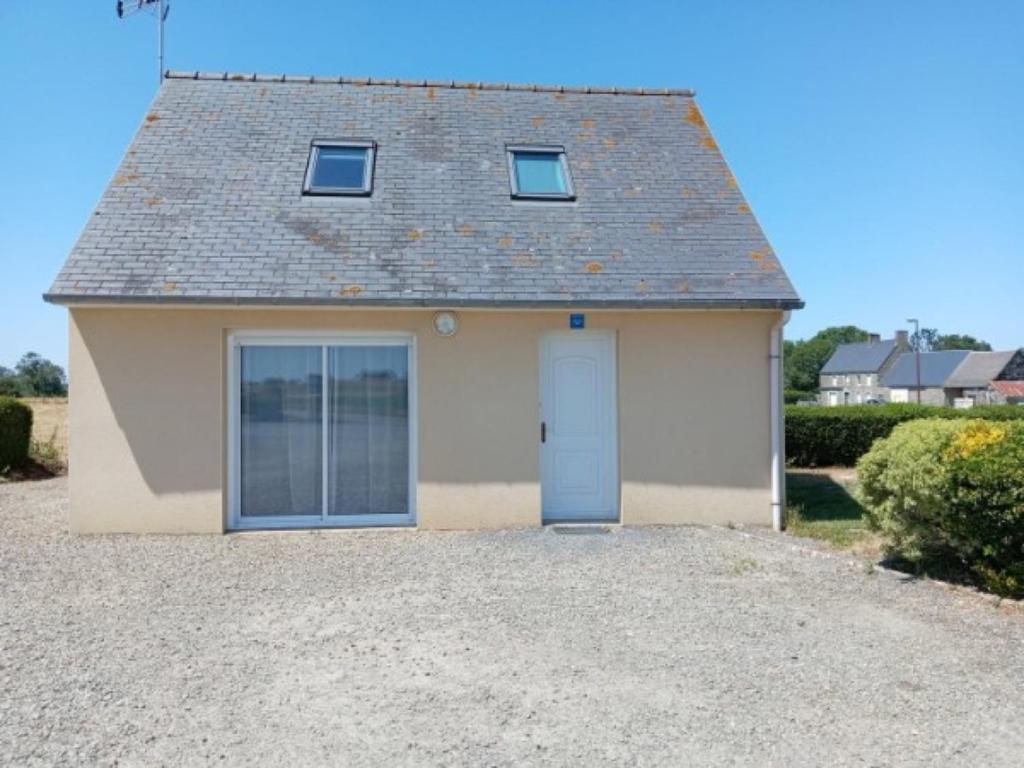 a small house with a blue door at Gite du neufbourg in Courtils