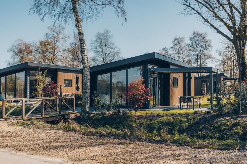 a house with a black roof and glass at De Leughte in Renswoude