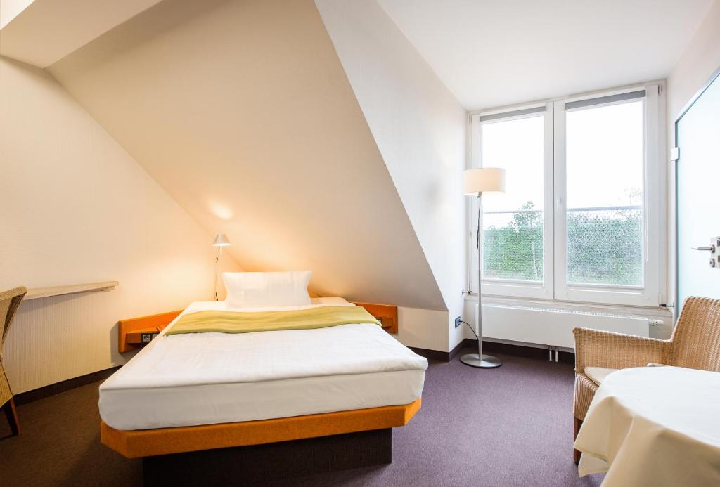 a small room with a bed and a window at Hotel Windschur in Sankt Peter-Ording