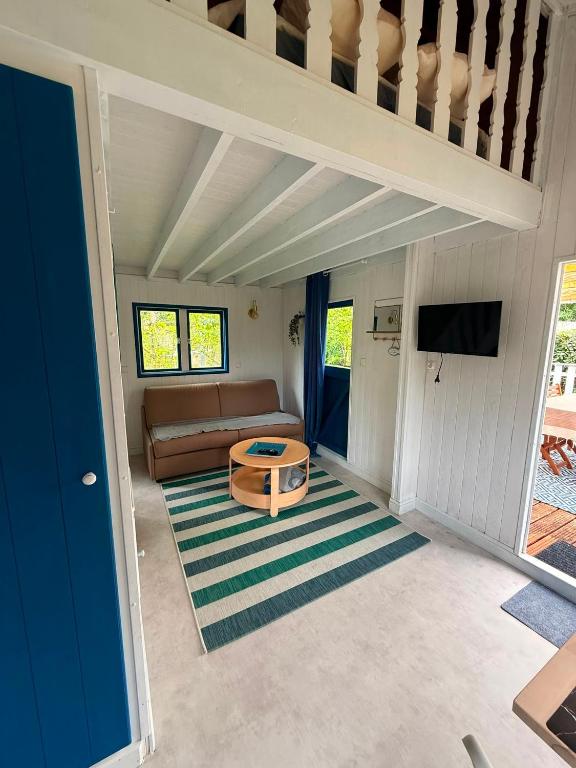 a living room with a couch and a table at La Cabane du Pti' Bonheur in Saint-Coulomb