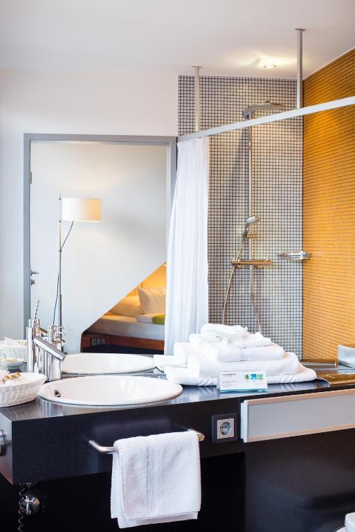 a bathroom with a sink and a large mirror at Hotel Windschur in Sankt Peter-Ording