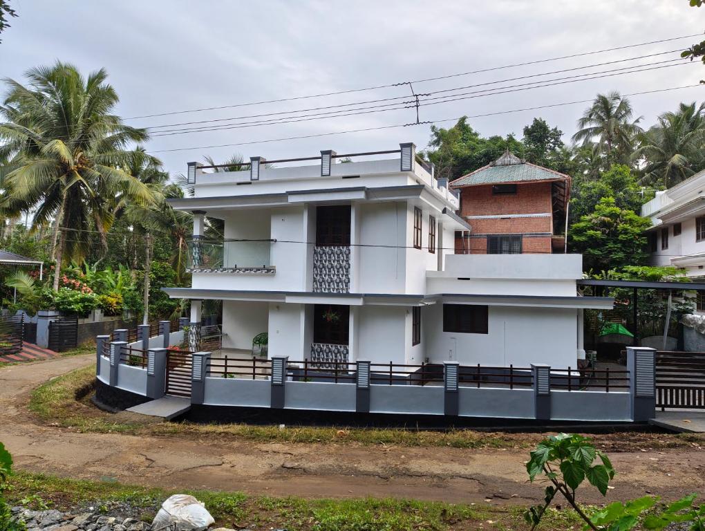 a white house with a fence in front of it at Future homes in Kunnamkulam