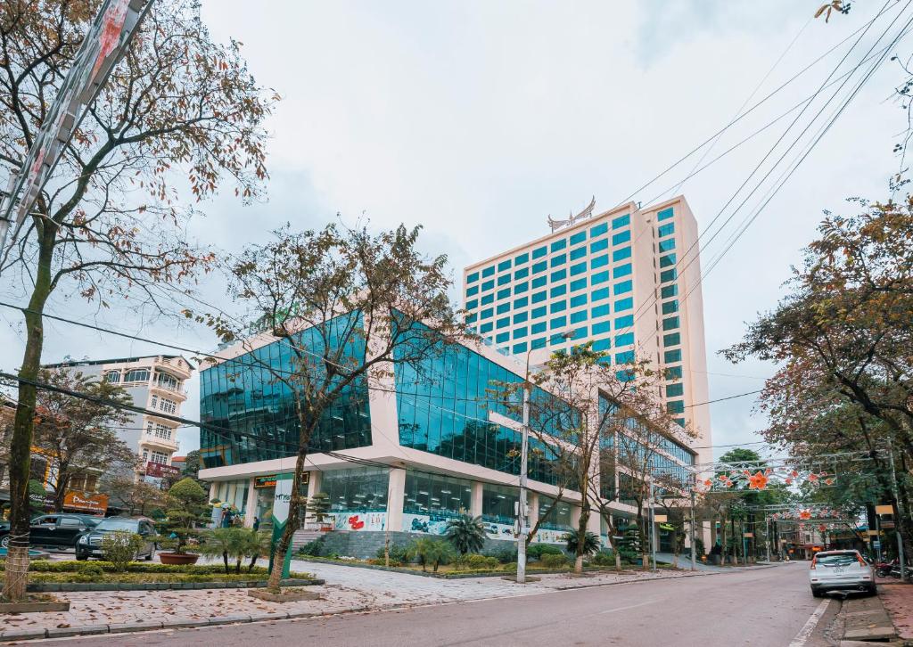 a large glass building on a city street at Muong Thanh Grand Lao Cai Hotel in Lao Cai