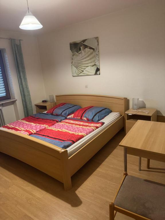 a bedroom with a large bed with blue and red pillows at Sempre Bello in Iffezheim