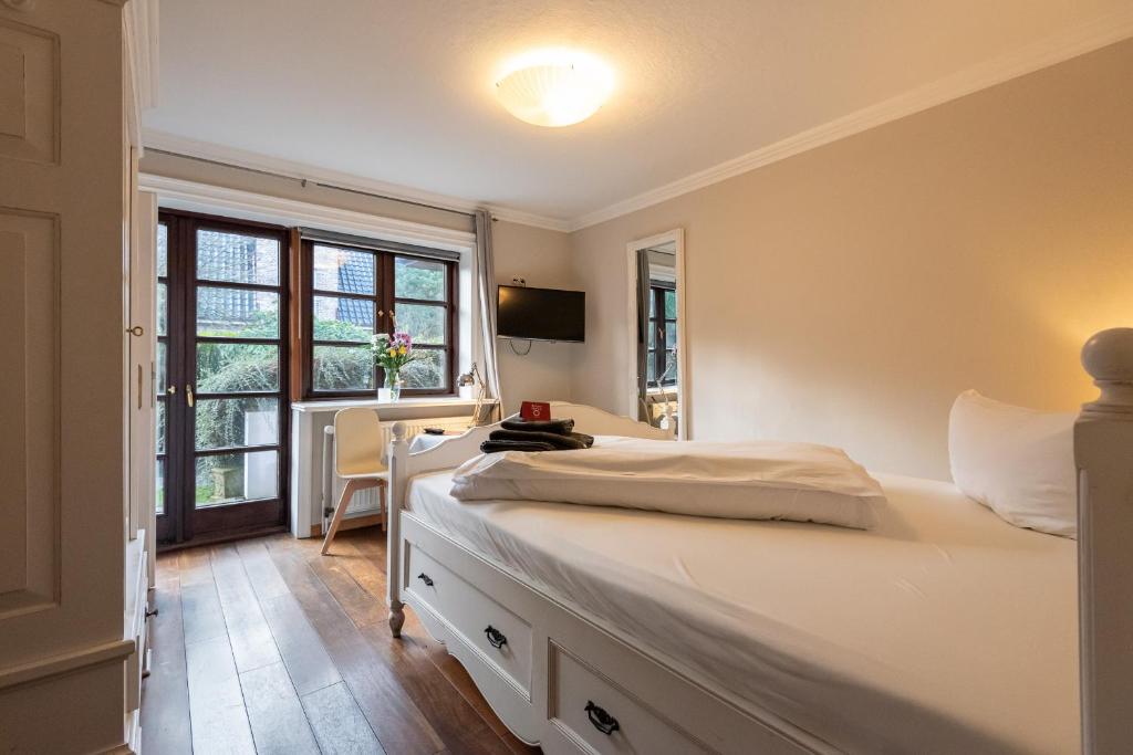 a bedroom with two beds and a desk and a window at Haus Strandkind in Sylt