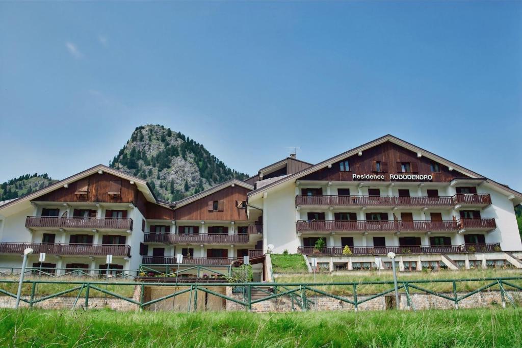 a hotel with a mountain in the background at Residence Rododendro in Passo San Pellegrino