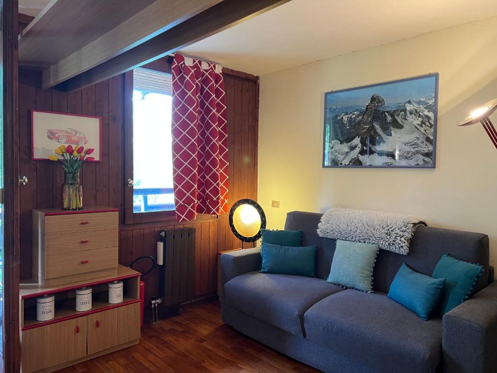 a living room with a couch and a window at Cervinia Mountain View Apartments in Breuil-Cervinia