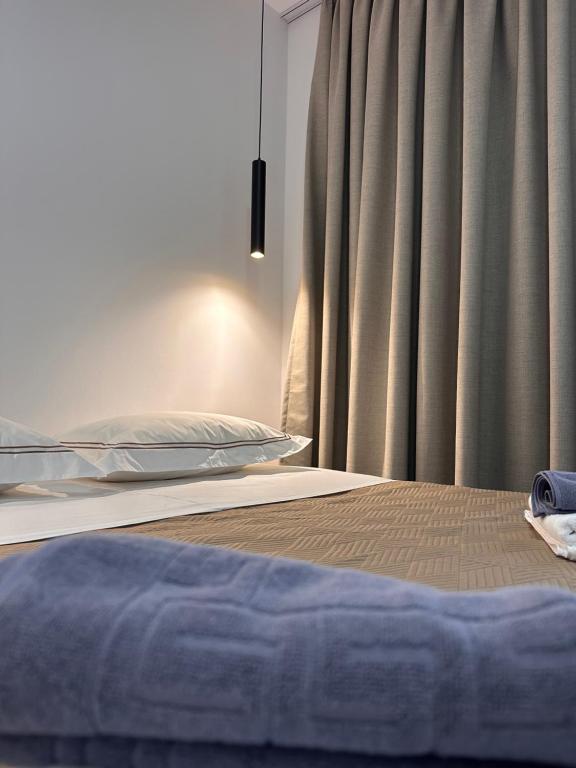 a bedroom with a bed and a window with curtains at Escape by Ambelas in Himare