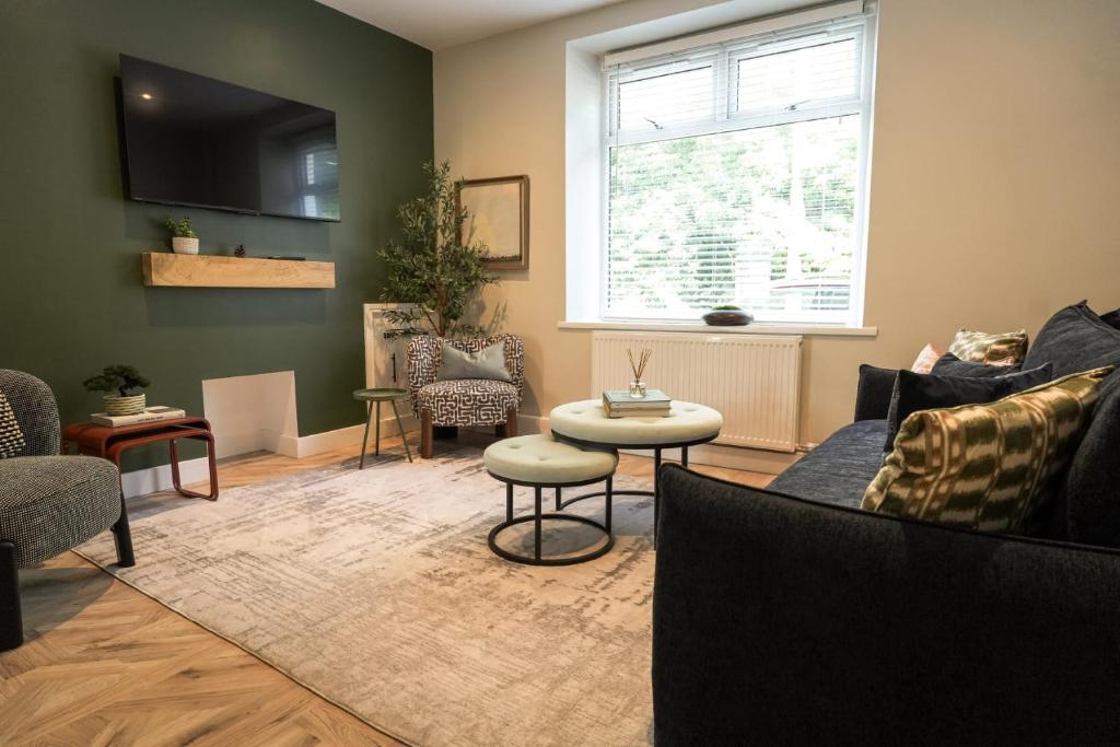 a living room with a couch and chairs and a table at Park House by Tŷ SA in Aberdare