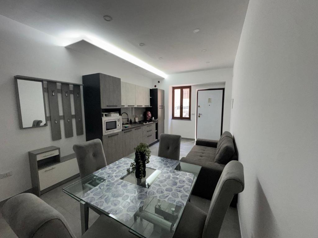 a living room with a dining table and a kitchen at La dimora dei Giglianti in Brusciano