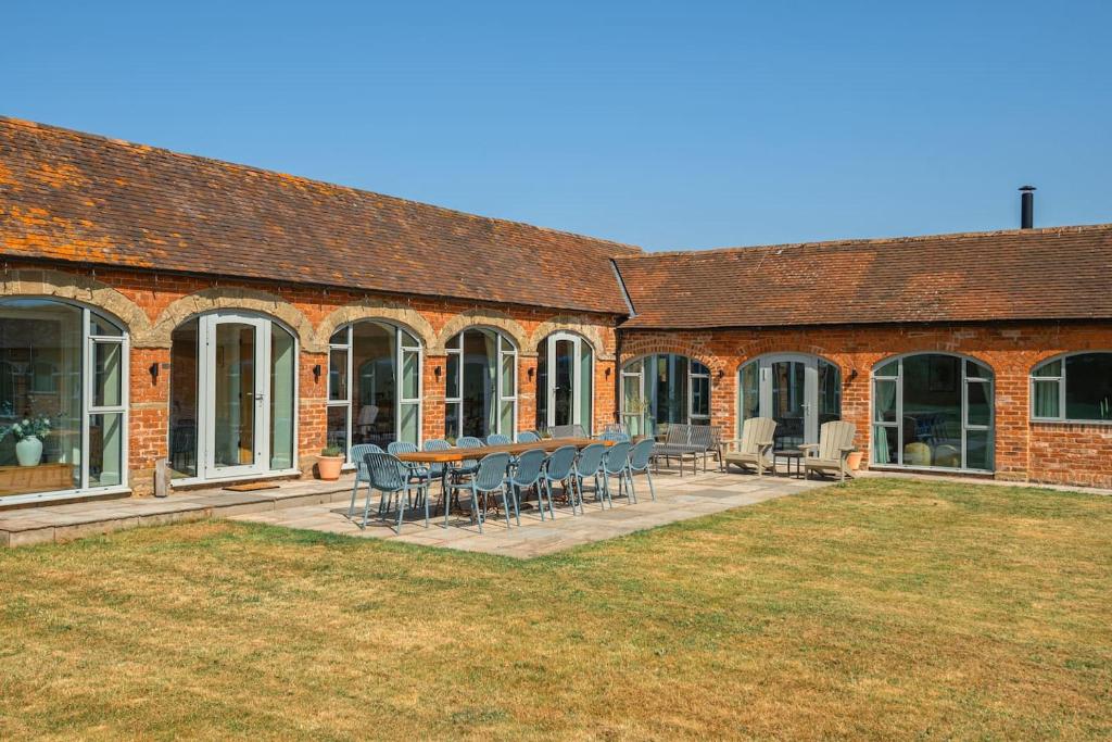 a brick building with chairs and a table in the yard at Scenic Barn Conversion in Rural Shropshire in Craven Arms
