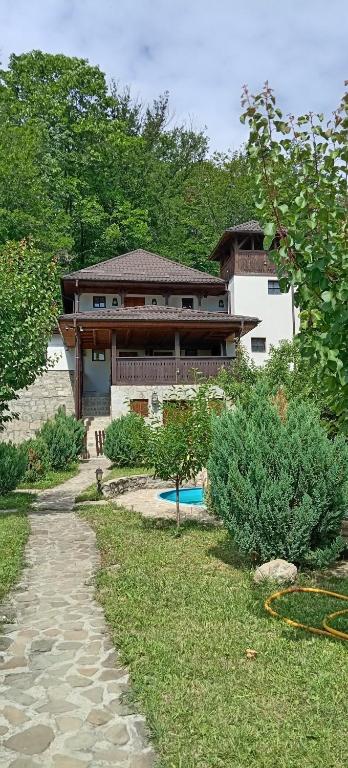 a house with a pathway in front of a building at Casa cu Turn in Sărata-Monteoru
