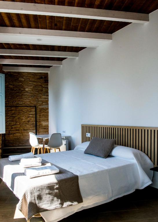 a bedroom with a large bed with a wooden ceiling at A Calexa Sarria nº3 in Sarria