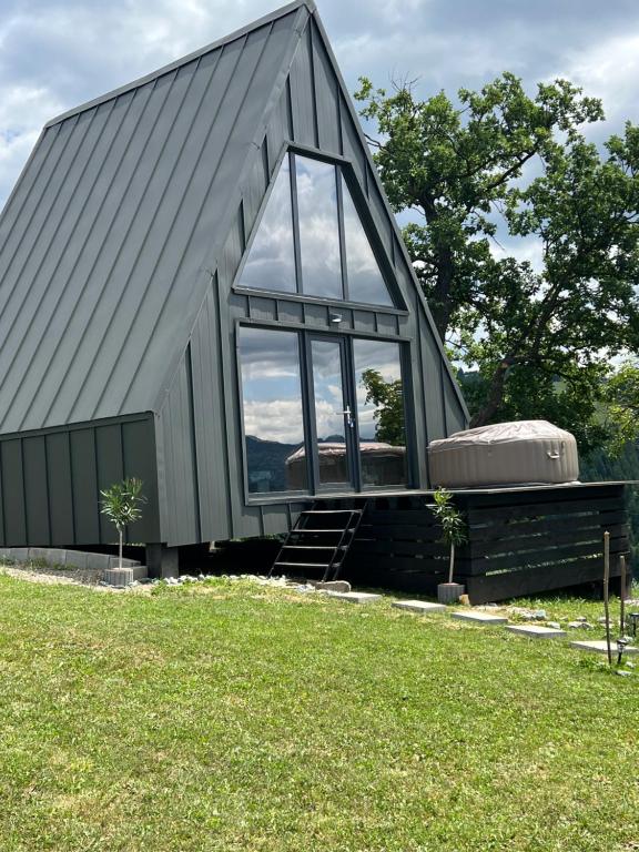 a large metal building with a large window at Vis de Munte Chalet in Buhalniţa