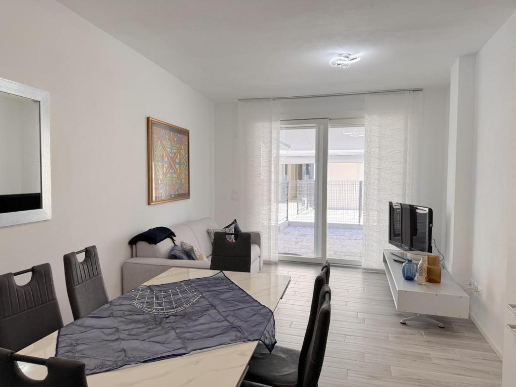 a living room with a dining table and a television at golf time apartment - Lido di Venezia in Venice