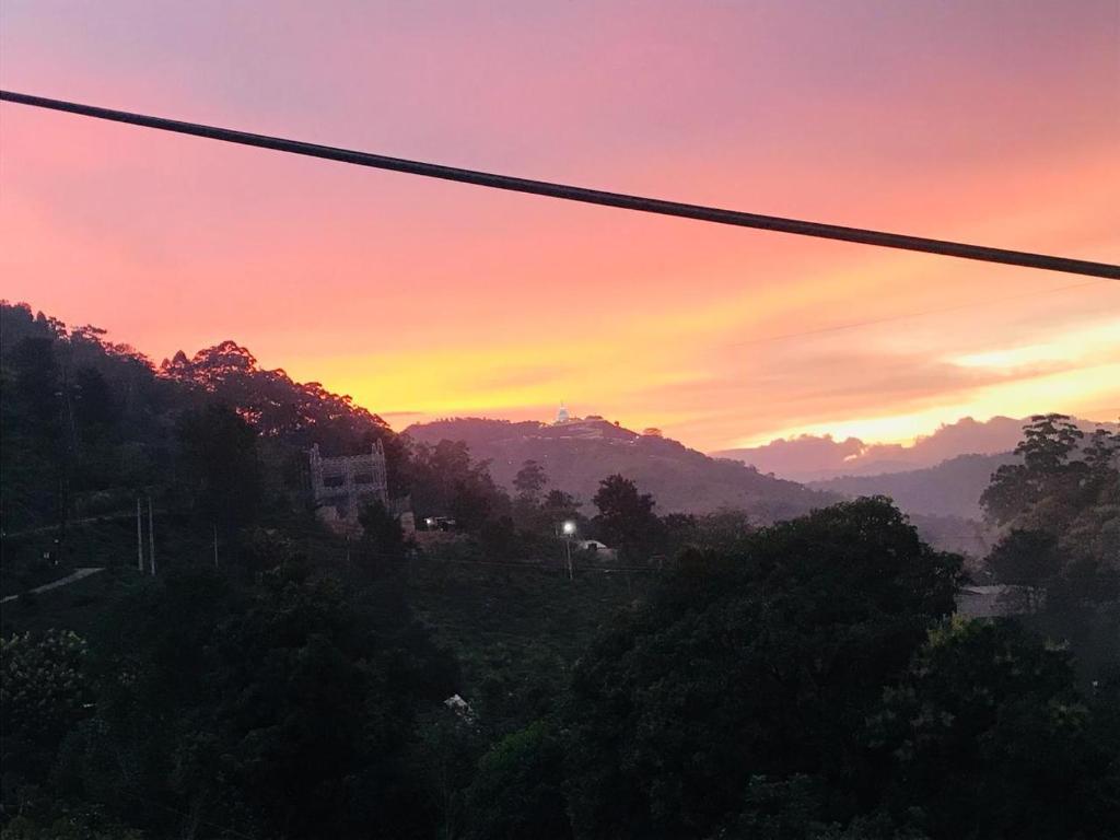 a sunset with a view of a mountain at Emerald mirror guest Ella in Ella