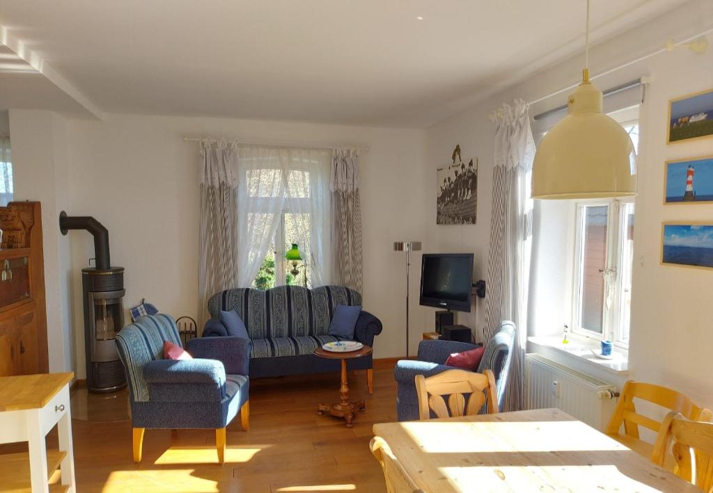 a living room with blue couches and a tv at Lotsenwohnung B-9 in Butjadingen