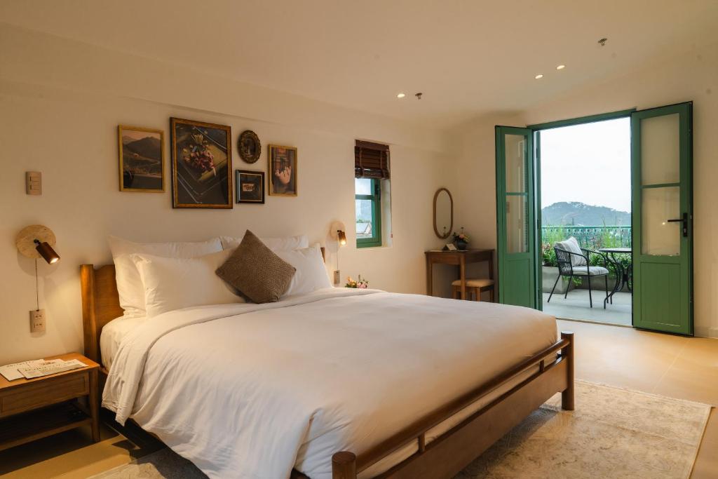 a bedroom with a large bed and a balcony at dei Balconi Dalat in Ấp Ða Lợi