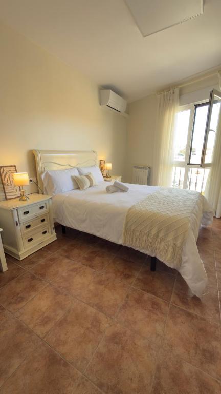 a bedroom with a large white bed and a window at Hostal Valderas in Valderas