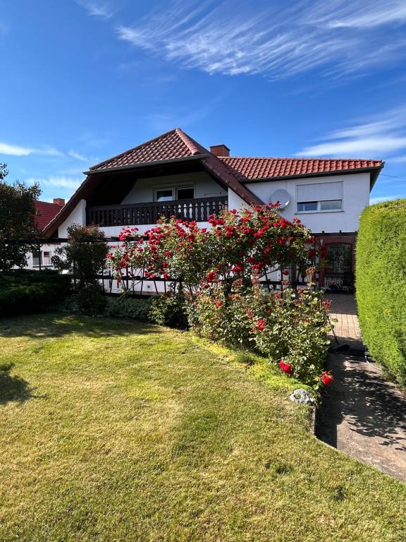 a house with a fence and flowers in the yard at Strandläufers Ruhe in Wiepkenhagen