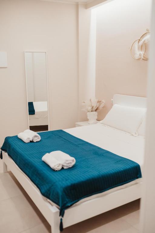 a white bedroom with a bed with towels on it at Corte Altobelli Rooms Bitonto in Bitonto