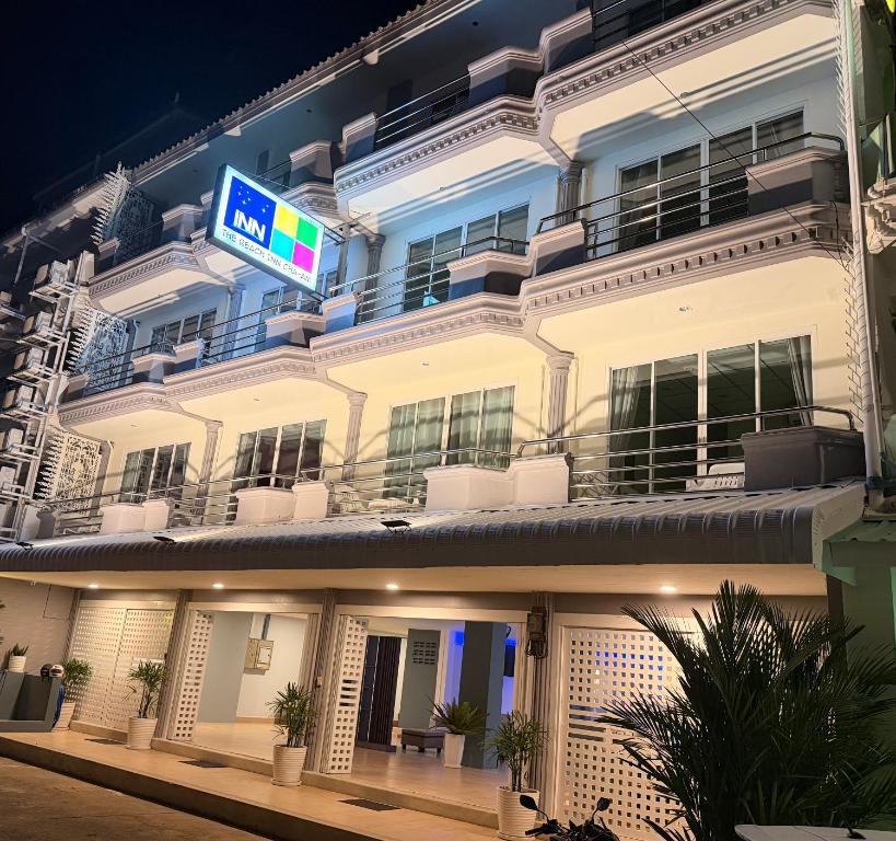 a large white building with a sign on it at THE BEACH INN Cha-Am in Cha Am
