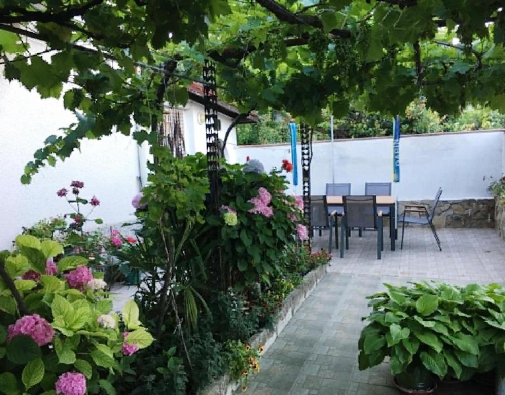a garden with a table and chairs and flowers at Къща Йорданови in Chernomorets