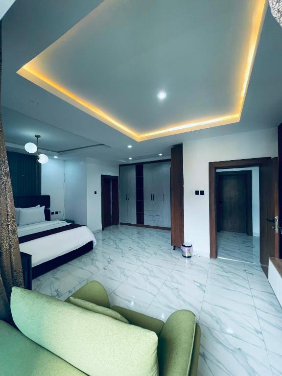 a bedroom with a bed and a couch in a room at Soilsmart Haven in Abuja