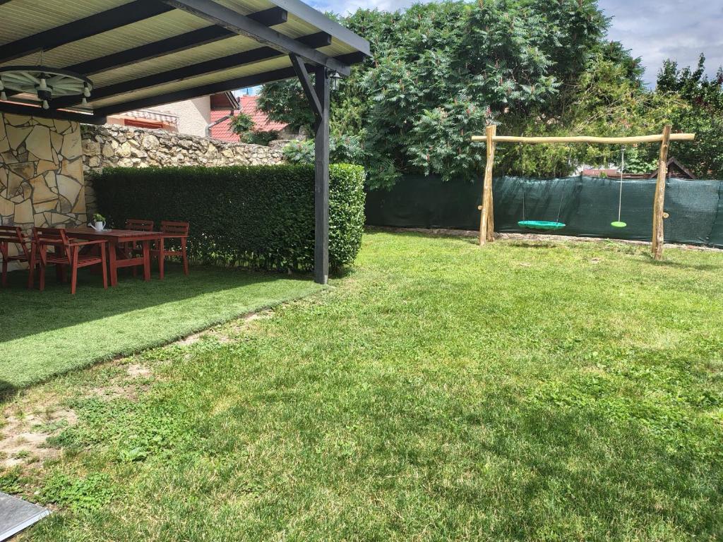 a backyard with a table and a swing at Vén Malom Apartman in Zalaszentgrót