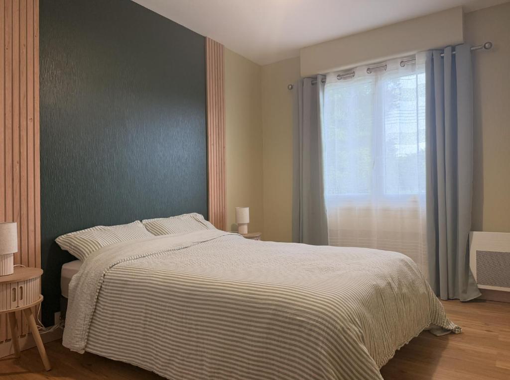 a bedroom with a large bed and a window at La Maison du Bocage in Saint-Mesmin