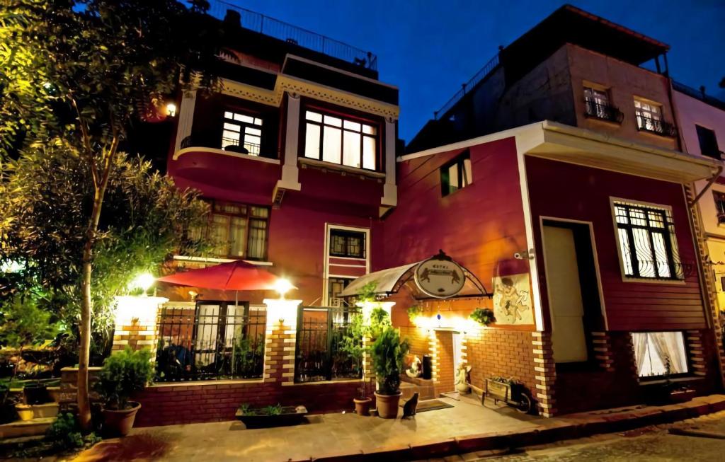a red building with a clock on it at night at Angel's Home Hotel - Angel Group Hotels in Istanbul
