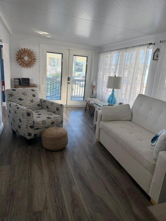 a living room with a white couch and a chair at Beach Bum Bungalow in Jensen Beach