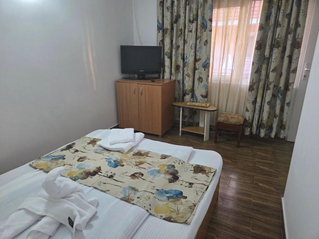 a bedroom with a bed with towels on it at La Camuflaj 2 Mai in 2 Mai